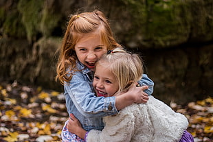 female toddlers hugging each other near stone HD wallpaper
