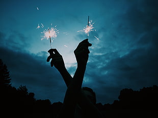 person holding two sparklers HD wallpaper