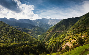 photography of green mountain under cloudy sky during daytime