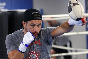 man in gray t-shirt boxing white speedbag