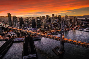 top view photo of bridge and high-rise buildings during sunset, bay bridge