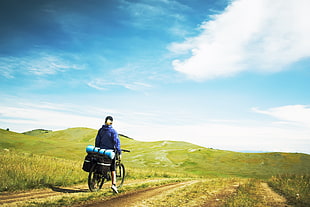 person in blue jacket riding bicycle during daytime HD wallpaper