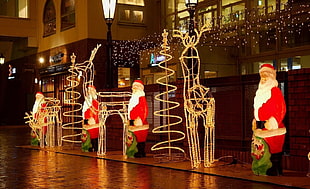 four Santa Claus statues HD wallpaper