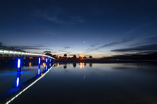 timelapse photography body of water beside bridge during sunrise