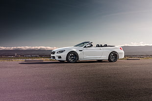 white convertible coupe parked under dark sky