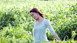 woman in gray elbow-sleeved top in field with green leaf plants during daytime HD wallpaper