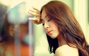 brown haired woman leaning on glass window