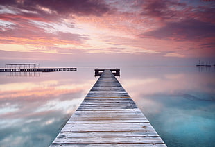 gray wooden dock pathway leading to river