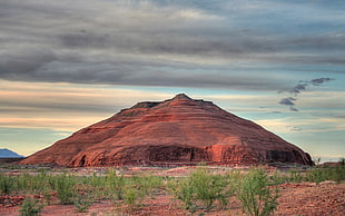 brown mountain under cloudy clouds