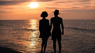 silhouette of man and woman in the beach HD wallpaper