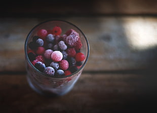 red and black berries on clear glass cup