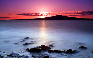 ocean view surrounded by silhouette mountain