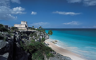 white stone castle near seashore under calm sky