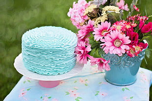 pink and yellow flowers on blue ceramic vase beside blue cake HD wallpaper