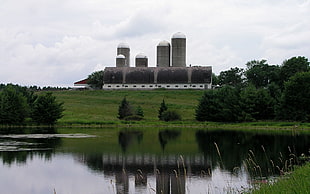 landscape photo of factory near green grass field HD wallpaper