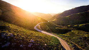 high angle shot of road surrounded by plants near mountains HD wallpaper