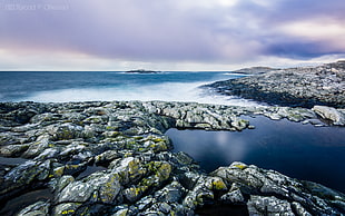 grey stone and blue ocean under white skies HD wallpaper