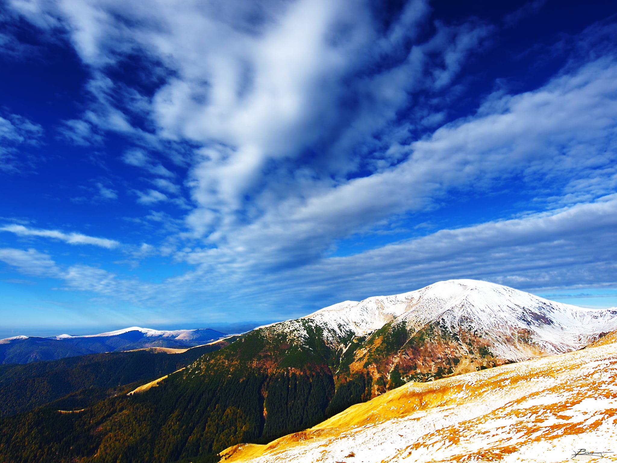 grass mountain under cloudy sky during daytime