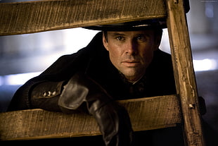 closeup photo of man in black long-sleeved top wearing black leather hat HD wallpaper