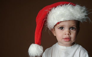 baby in white shirt wearing white and red Santa Claus hat HD wallpaper