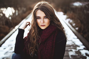 woman in the middle of road wearing black sweater with red scarf