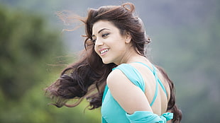 woman wears blue sleeveless top waving hair