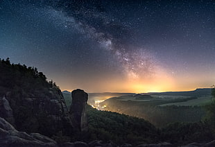 brown rocky mountain surrounded by green trees during nighttime HD wallpaper