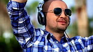 man in plaid shirt wearing headphones in tilt shift photography HD wallpaper