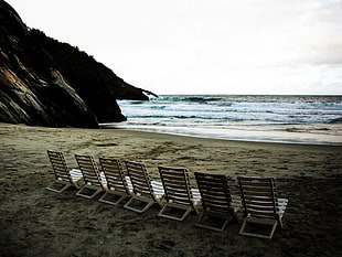 white beach lounger near ocean under white skies HD wallpaper