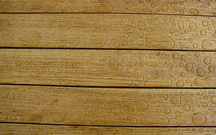 close up photo of water on brown wooden surface