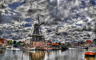 time lapse photography of windmills between on town and river under stratocumulus clouds HD wallpaper