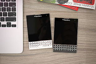 photo of two black Berry QWERTY phones on table HD wallpaper