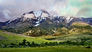 landscape photography of green fields and snow covered mountain range