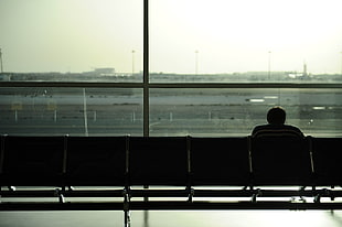 silhouette photo of sitting person on airport waiting area HD wallpaper