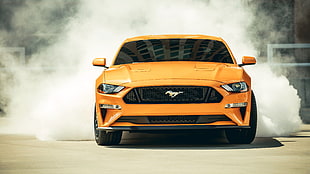 yellow Ford Mustang on grey asphalt road during daytime