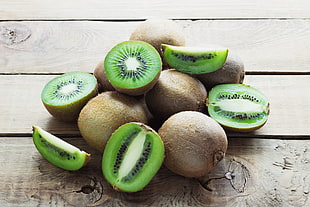 bunch of Kiwi on brown wooden surface HD wallpaper