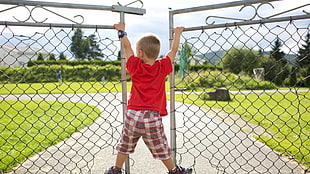 children's red crew-neck t-shirt and gray shorts holding wires