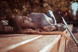 woman lying on floor with skateboard during daytime