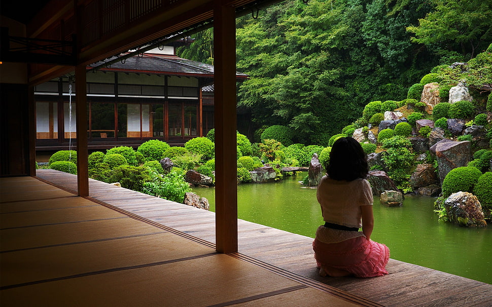 woman sitting near body of water during daytime HD wallpaper