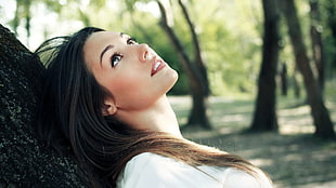 selective focus photography of woman lying on tree