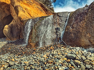 gray ceramic with tripod facing water falls