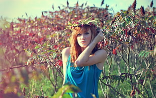 woman in blue sleeveless top beside tree