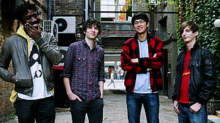 four men standing near building during daytime