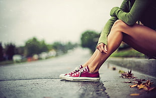 person wearing pair of maroon-and-white low-top sneakers