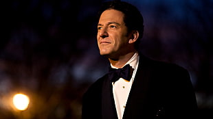 man wearing black notch-lapel suit jacket with bowtie