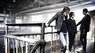three men band members standing beside brown metal handrails HD wallpaper