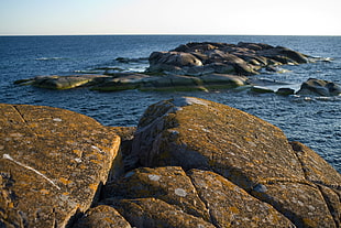 rock formation on body of water during daytime