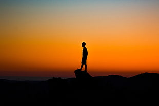 silhouette photo of man standing on rock, shilouettes, sunset, photography, orange HD wallpaper