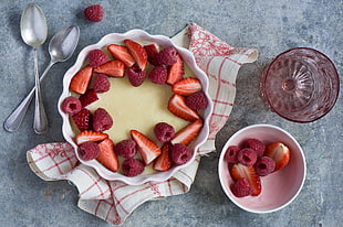 sliced strawberry and raspberry on bowl