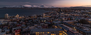 white concrete buildings, city, sunset, mountains, snow